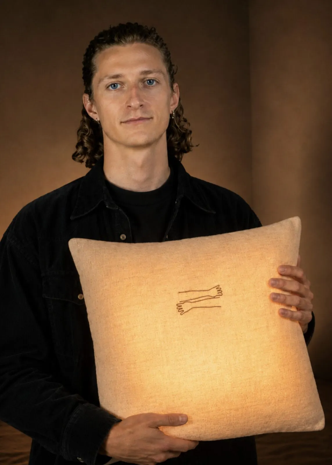 Laurens, founder of Miru Studio, holding a Held pillow